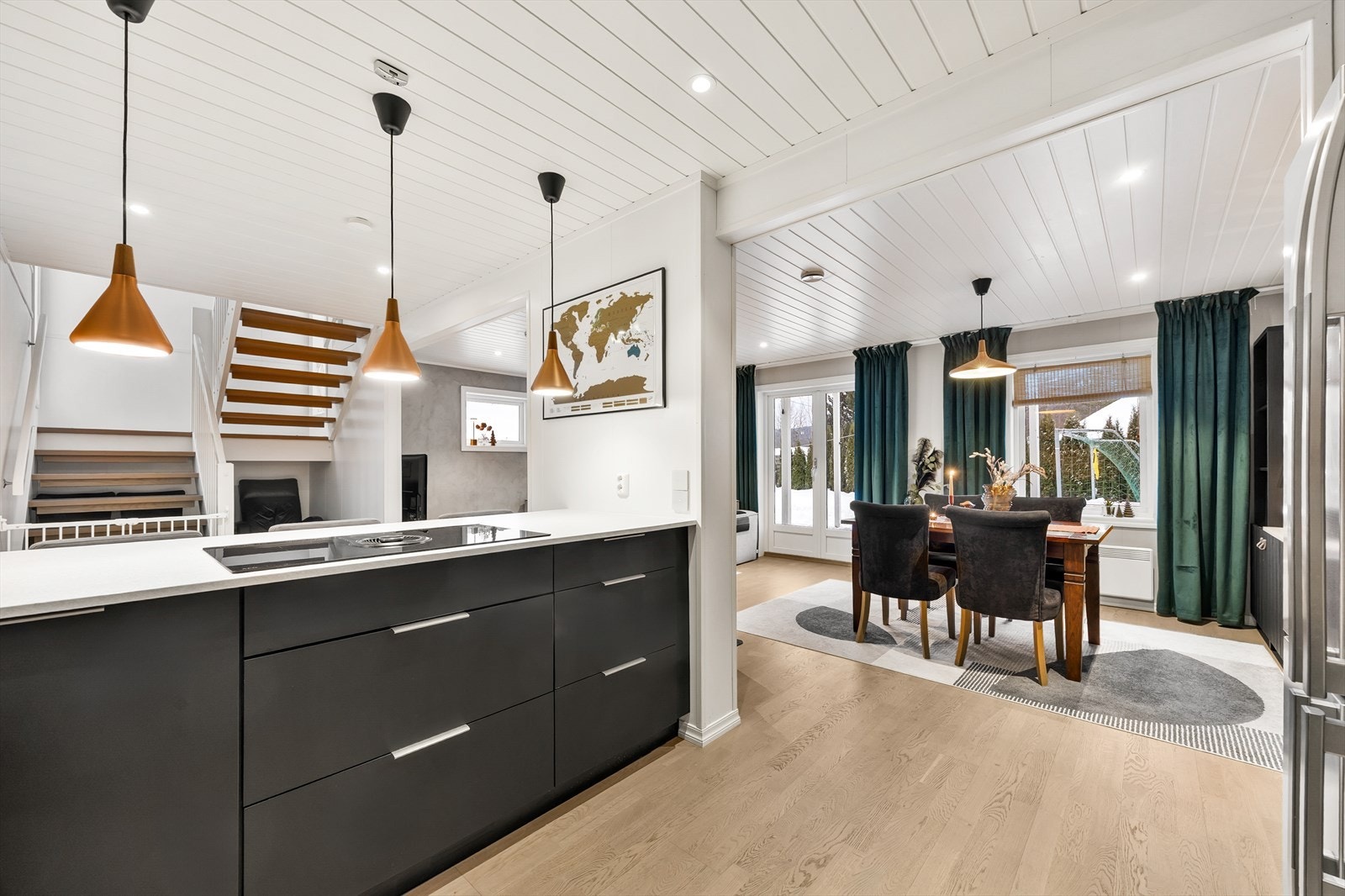 Her er det godt belyst med både downlights i tak og takpendler ved koketoppen. Galleribilde