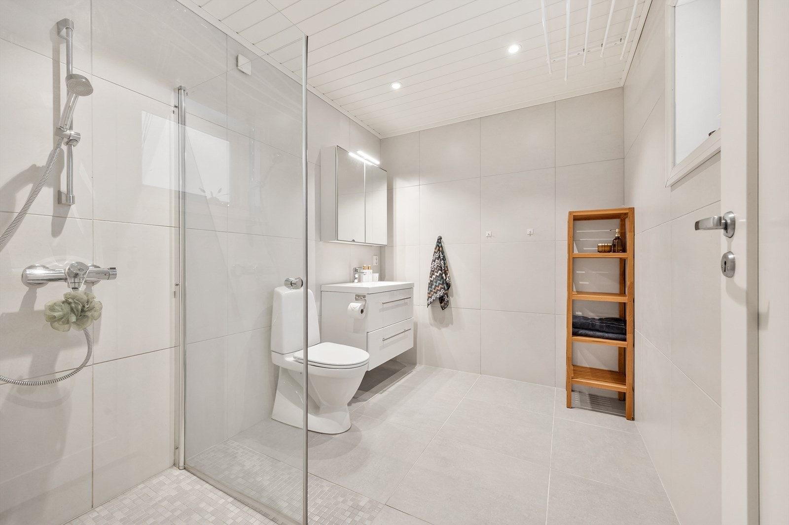 Pent baderom med flislagte gulv og vegger. Galleribilde