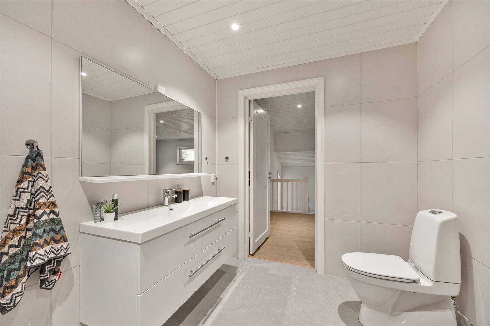 Badet er utstyrt med toalett, servant med skuffer og badekar. Galleribilde