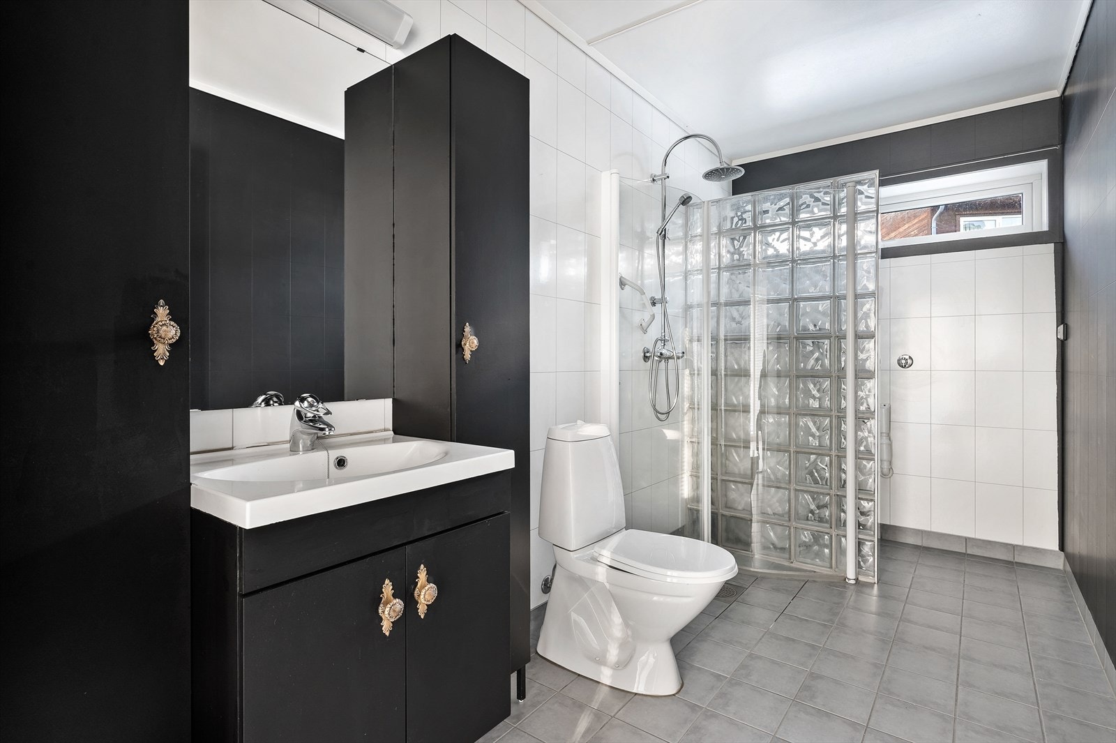 Romslig bad med toalett, servant, skap og dusjhjørne. Galleribilde