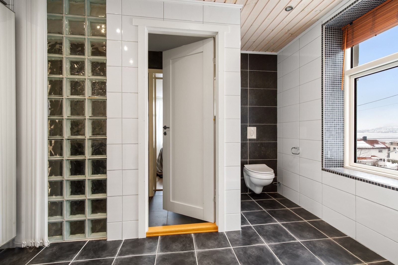 Rommet har flislagt gulv og vegger, varmekabler i gulvet og downlights i himlingen. Galleribilde