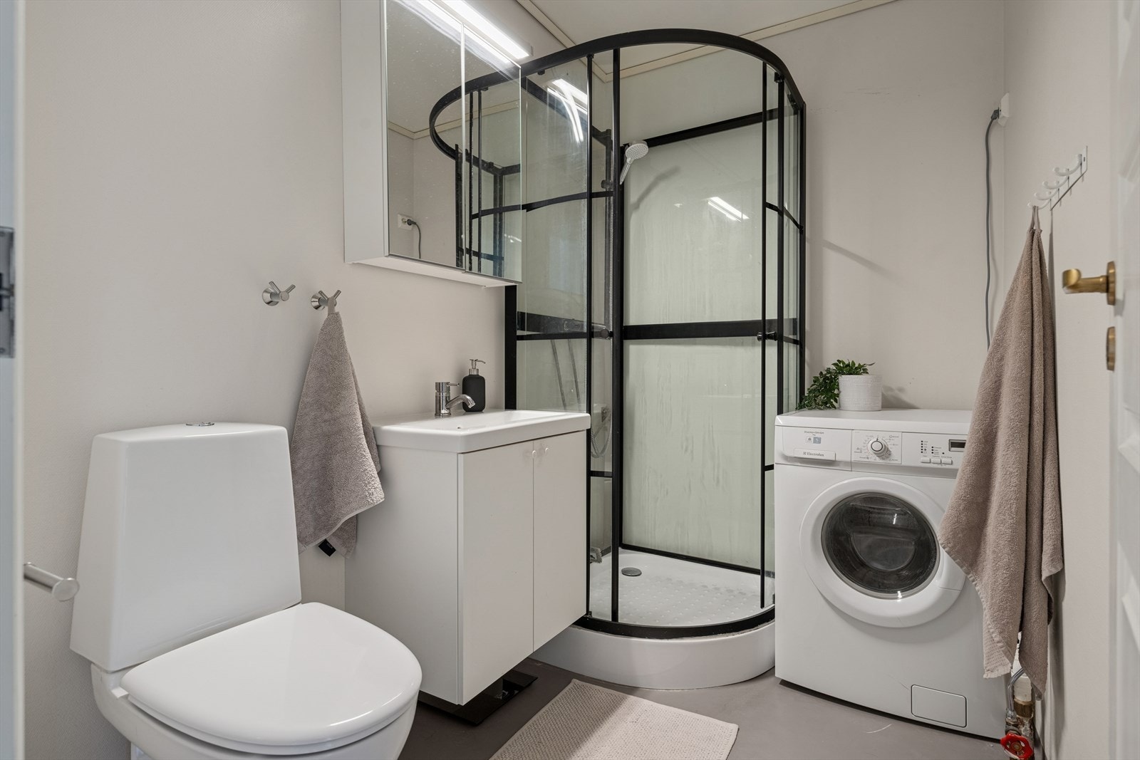 Badet er fra byggeår og har gulvbelegg med varmekabler og øvrige overflater er malt. Galleribilde