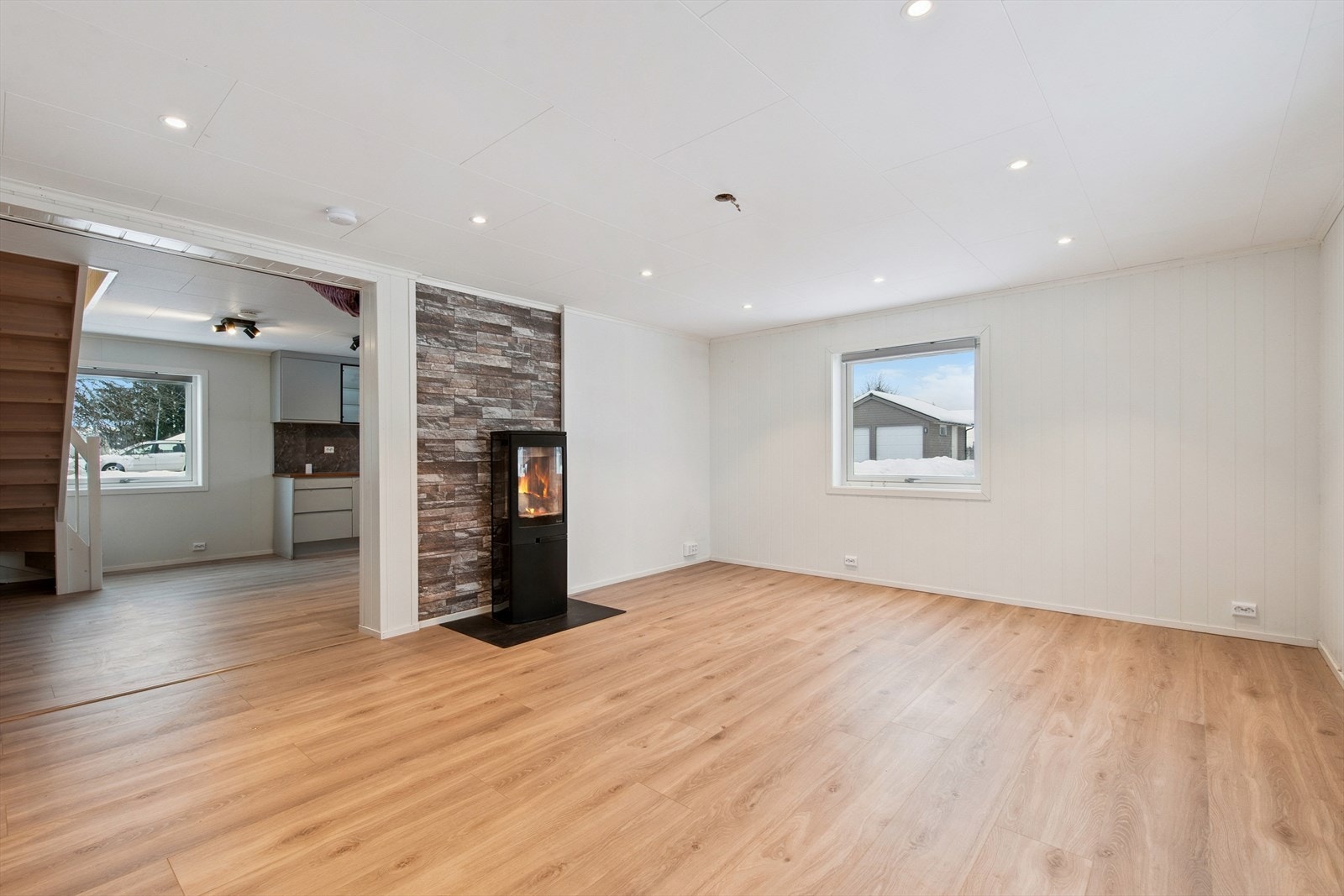 Den lyse stuen har en moderne peisovn som gir en lun atmosfære. Galleribilde