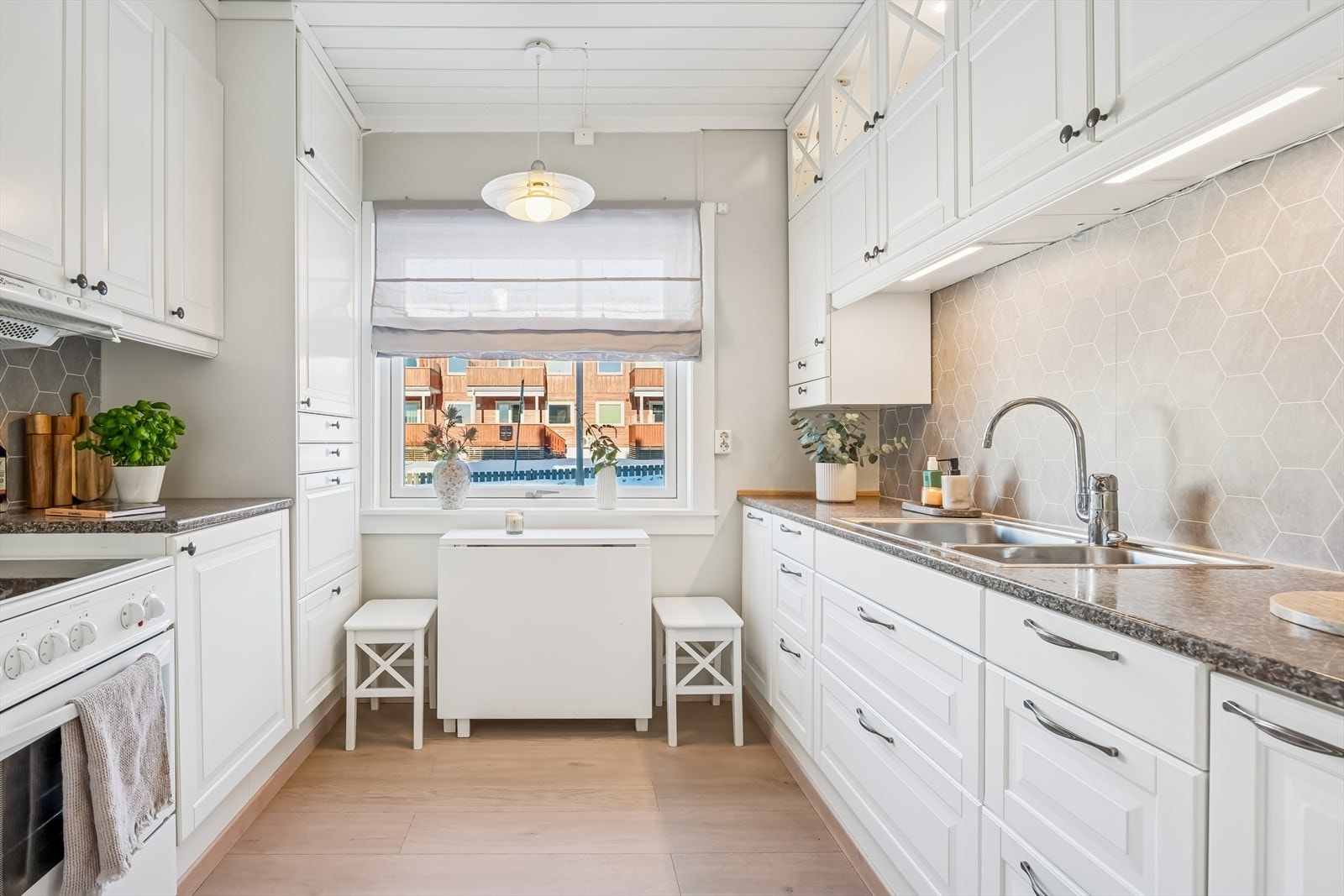 Lyst og romslig kjøkken med godt med skap og benkplass Galleribilde