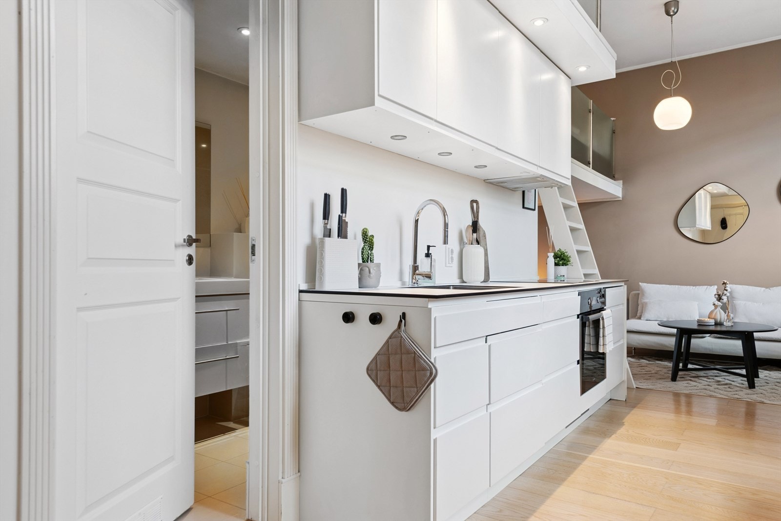 Leilighetens bad ligger praktisk til innenfor kjøkkenet, nær entréen Galleribilde