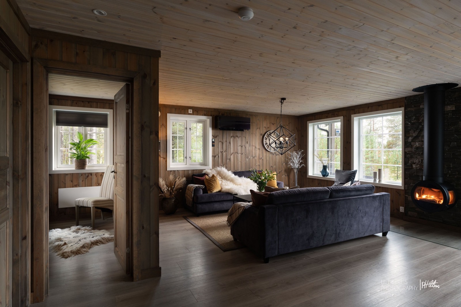 Stor stue med peisovn og vinduer som slipper inn rikelig med dagslys Galleribilde