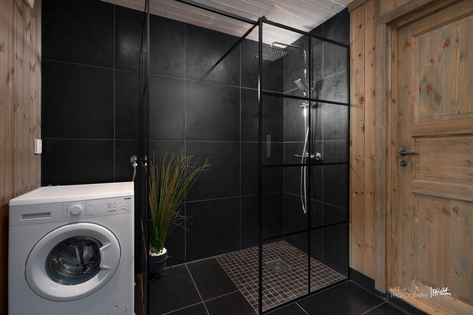 Lekkert baderom med sort flislagt dusjhjørne og regndusj Galleribilde