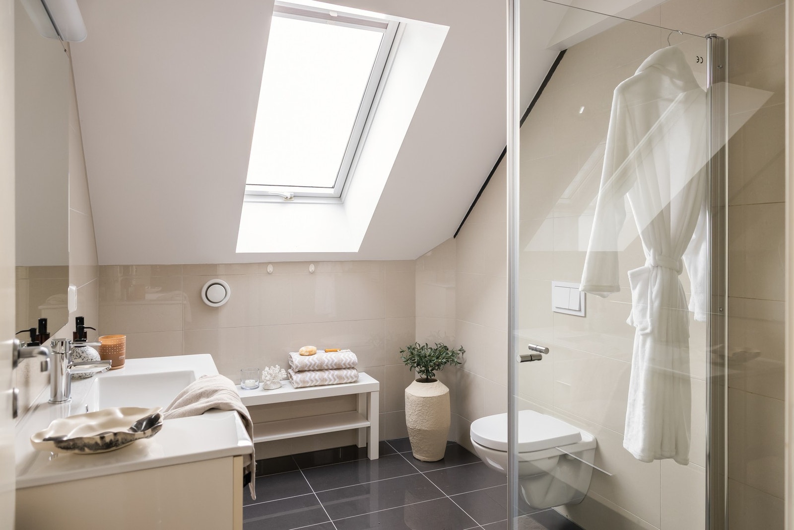 Boligens bad fremstår som særdeles lekkert med flislagte vegger og gulv. Galleribilde