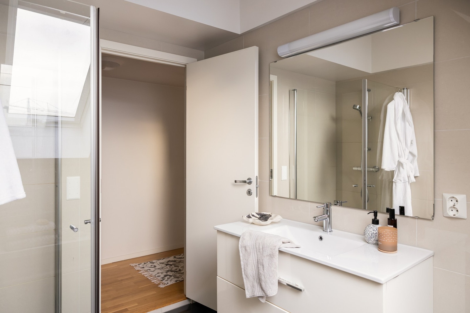 Her er dusjhjørne med innskyvbare glassdører, vegghengt wc og lys og fin baderomsinnredning. Galleribilde