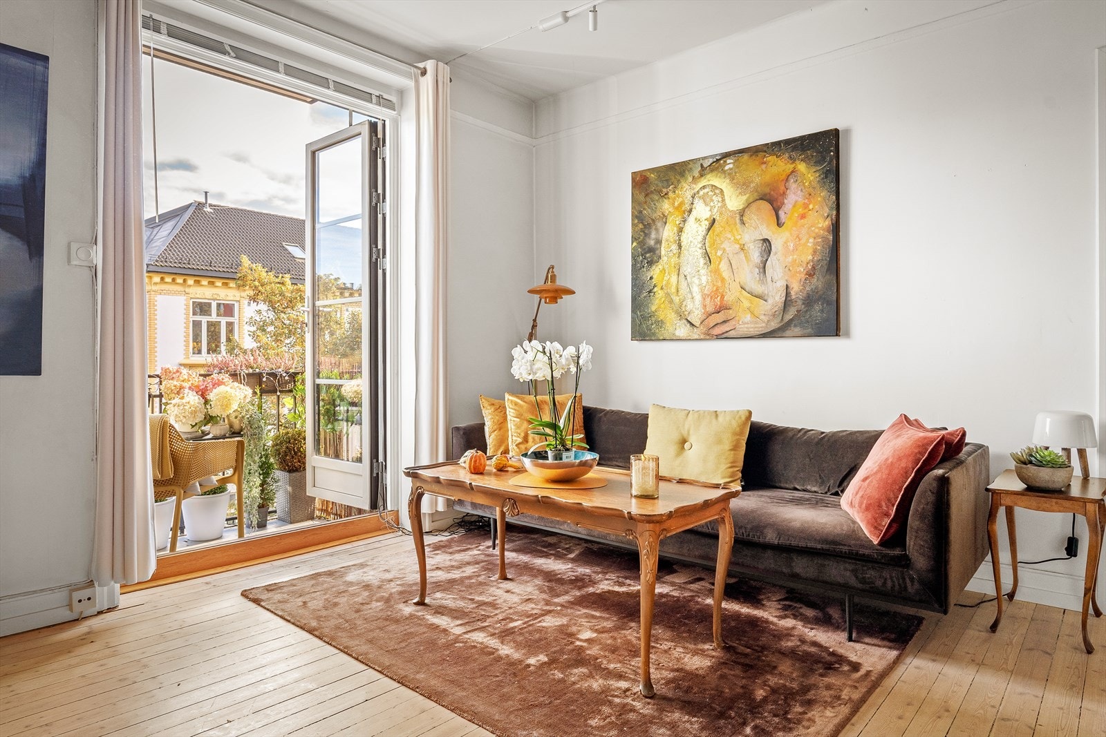 Fra stuen fører doble fløydører ut til en solrik balkong Galleribilde