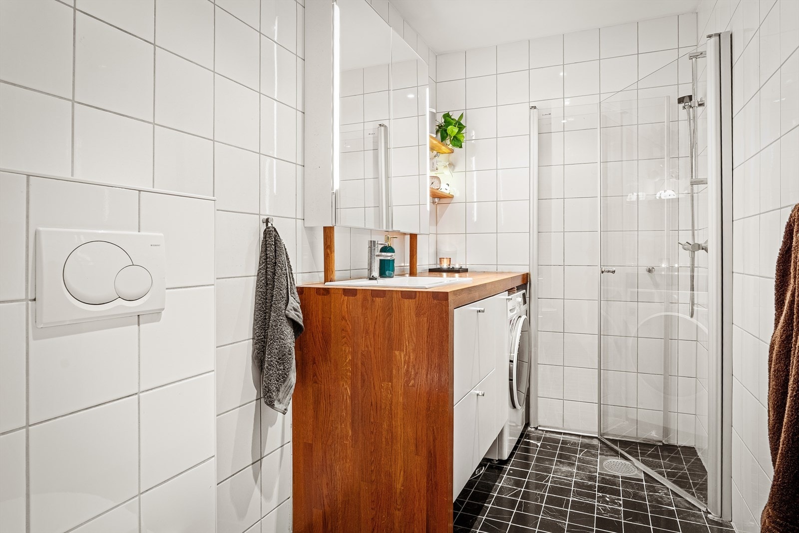 Delikat, flislagt bad, oppusset av aksjelaget i 2006, med varmekabler i gulvet og downlights i himlingen. Dusj med innfellbare glassdører og veggmontert toalett. Galleribilde