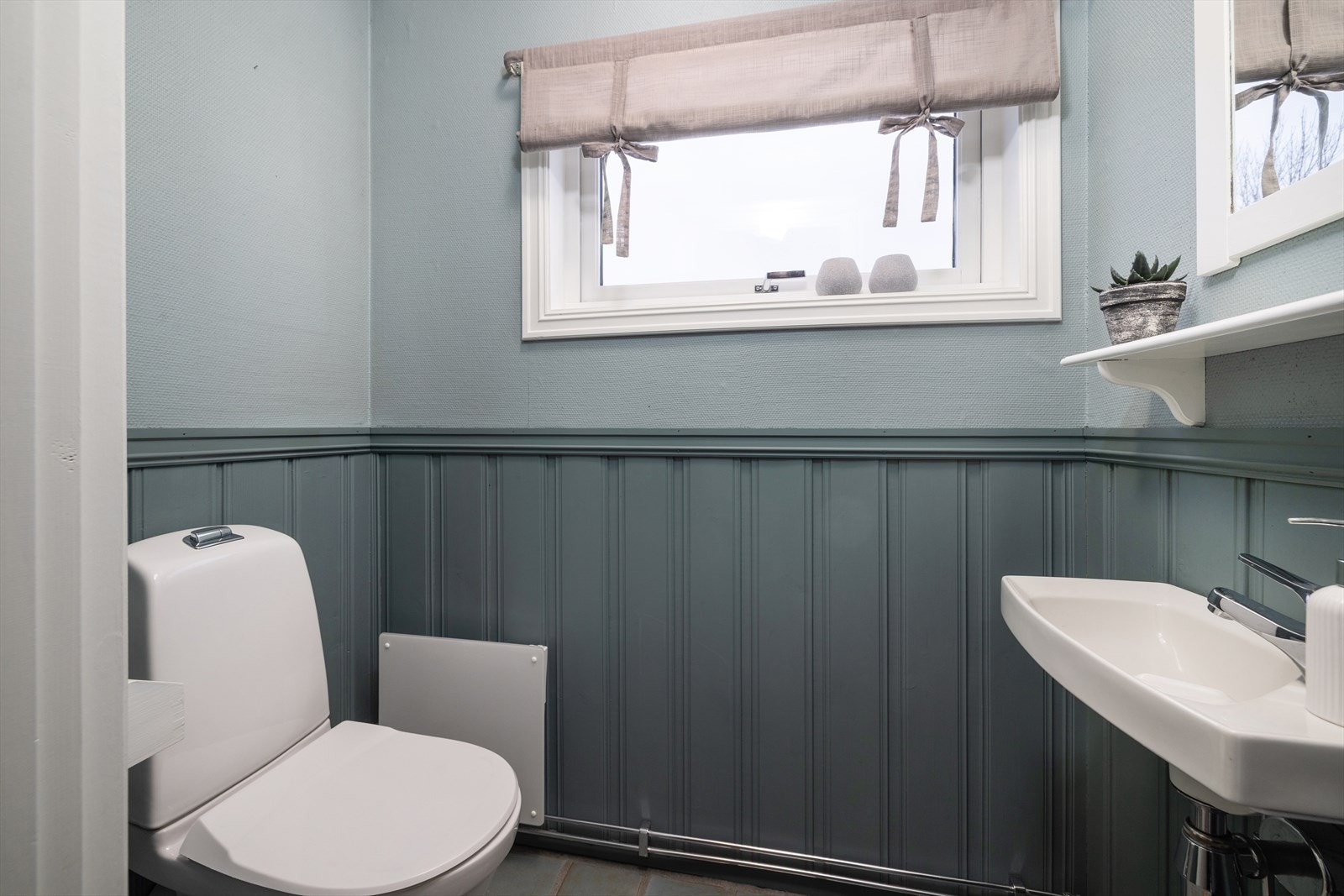 Praktisk toalettrom i første etasje med malt brystningspanel. Galleribilde