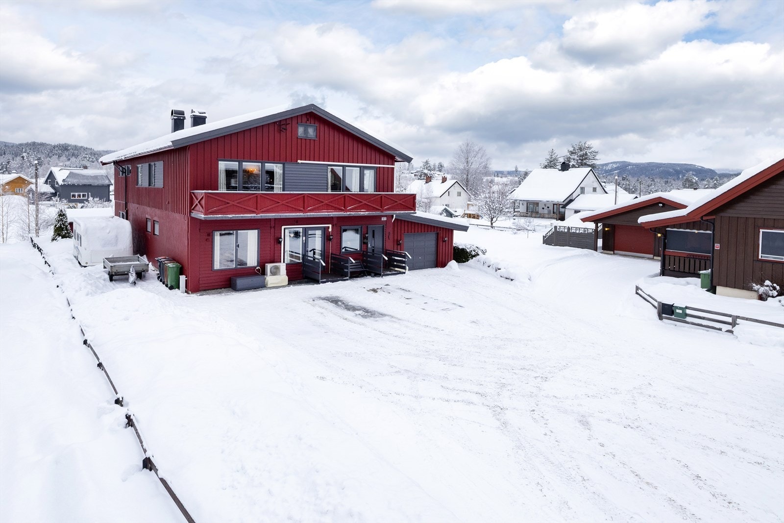 Eiendommen ligger på en flat tomt, opparbeidet med en stor, oppgruset parkeringsplass og hage. Galleribilde