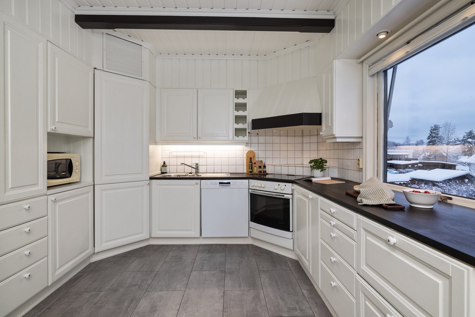 Kjøkkenet er utstyrt med platetopp, innbygget stekeovn og en solid benkeplate i beiset heltre. Galleribilde