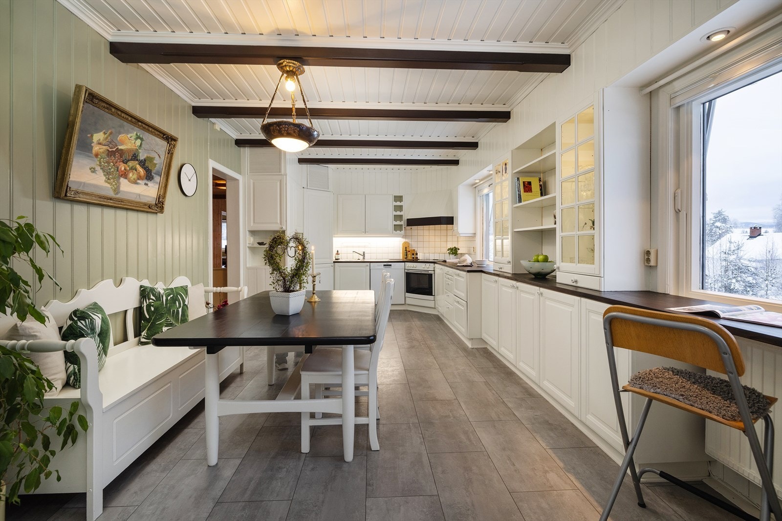 Kjøkkeninnredningen har profilerte hvite fronter og rikelig med skap- og benkeplass. Galleribilde