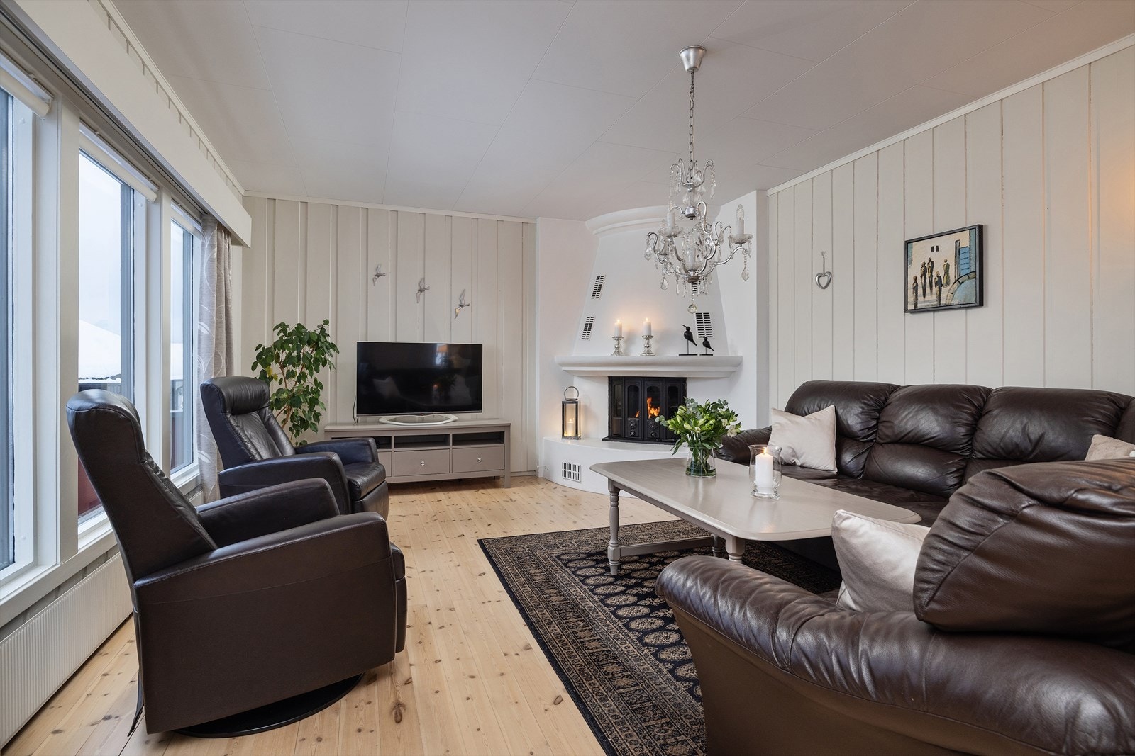 En murt peis med innsats skaper en lun atmosfære i stuen. Galleribilde