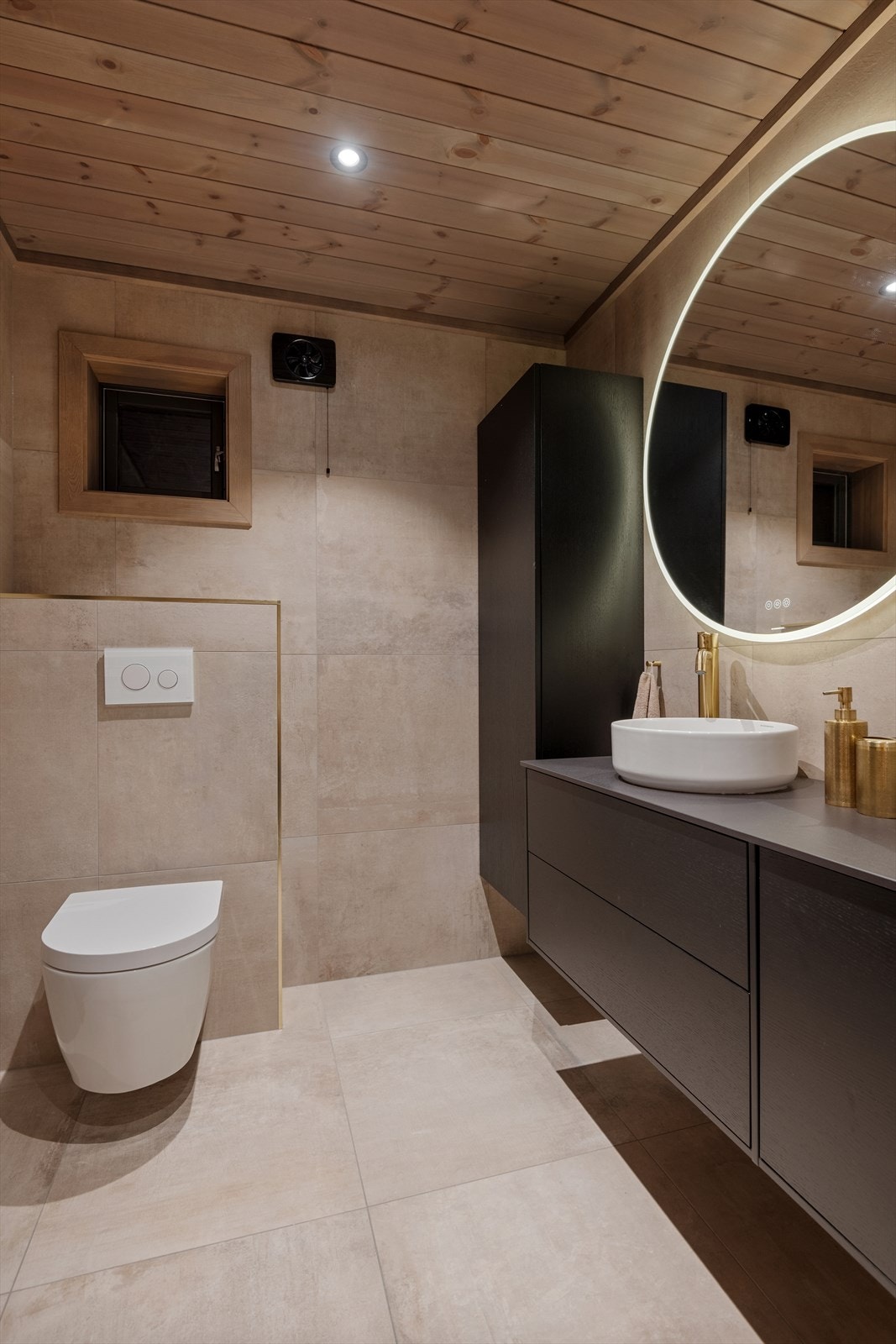 Bad/vaskerom er innredet med en baderomsinnredning med servant og ett-greps blandebatteri, vegghengt toalett, dusjhjørne med glassdører og opplegg for vaskemaskin. Galleribilde