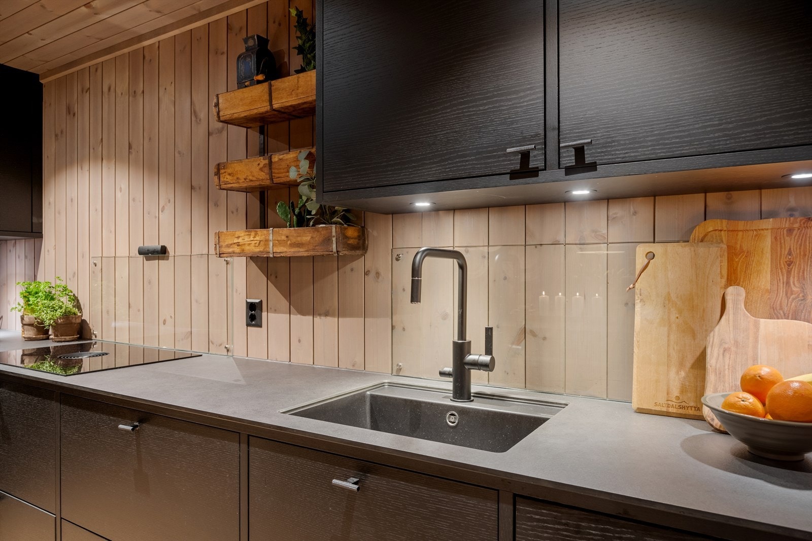 Benkeplaten er i laminat med en nedfelt komposittkum og ett-greps blandebatteri, og det er montert glassplater på veggen bak oppvaskkum og platetopp, noe som bidrar til et rent uttrykk og enkel rengjøring av overflatene. Galleribilde