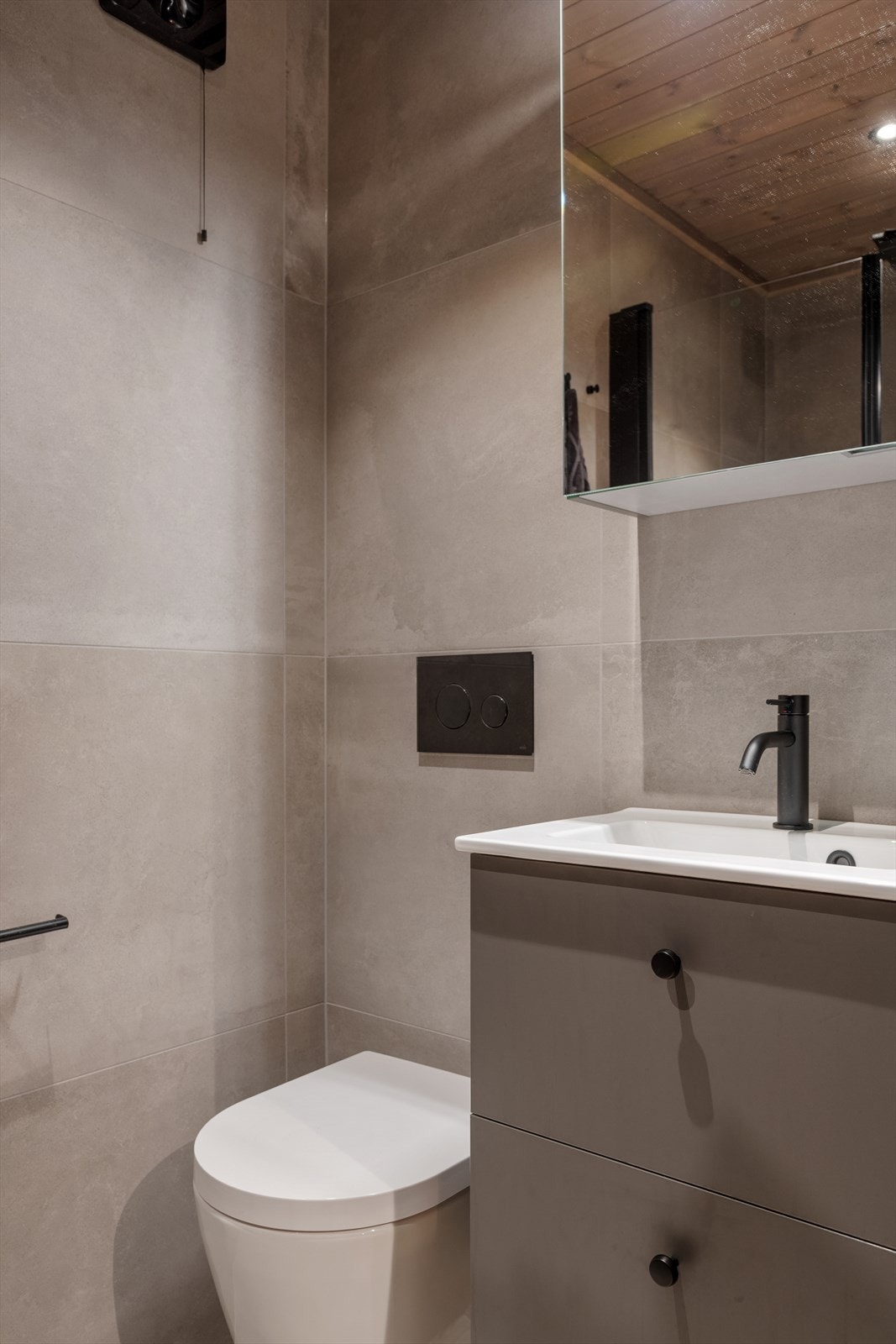 Boligens andre bad har baderomsinnredning med servant og ett-greps blandebatteri, vegghengt toalett og dusjhjørne med glassdører. Galleribilde