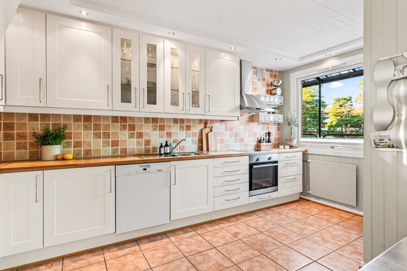 Kjøkkenet er utstyrt med hvitevarer som integrert stekeovn, oppvaskmaskin, keramisk platetopp og kjøleskap med fryser. Galleribilde