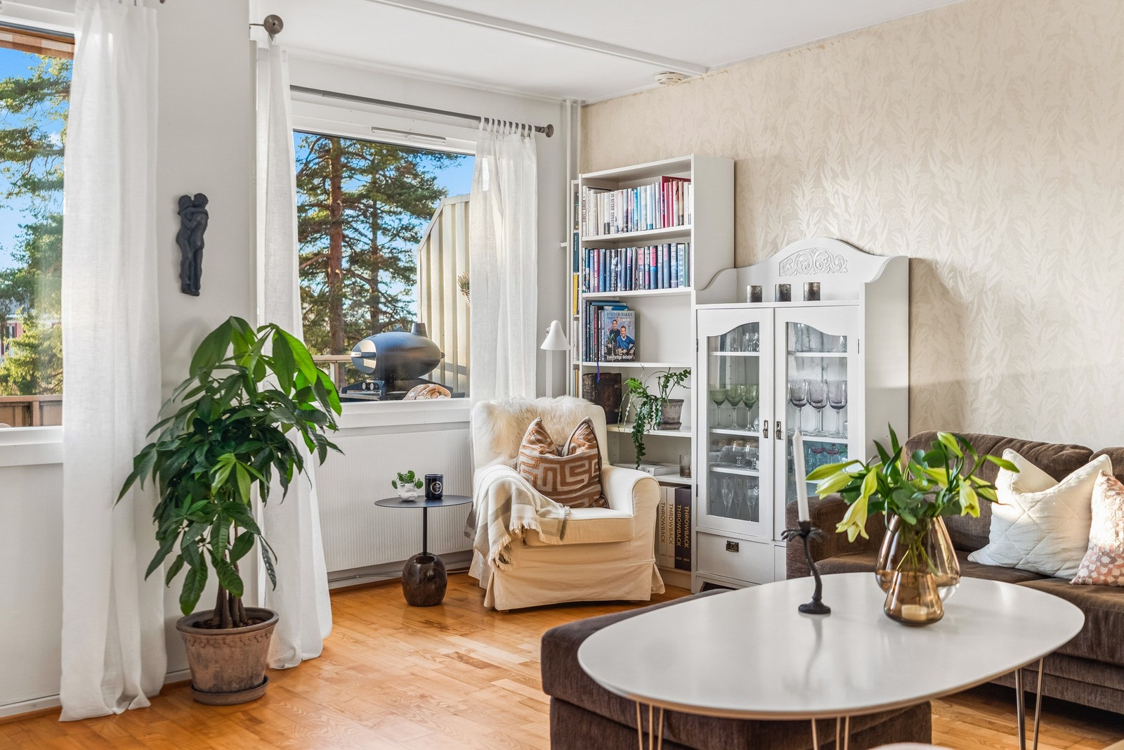 Lys stue med store vindusflater som slipper inn rikelig med dagslys og skaper en hyggelig atmosfære. Galleribilde