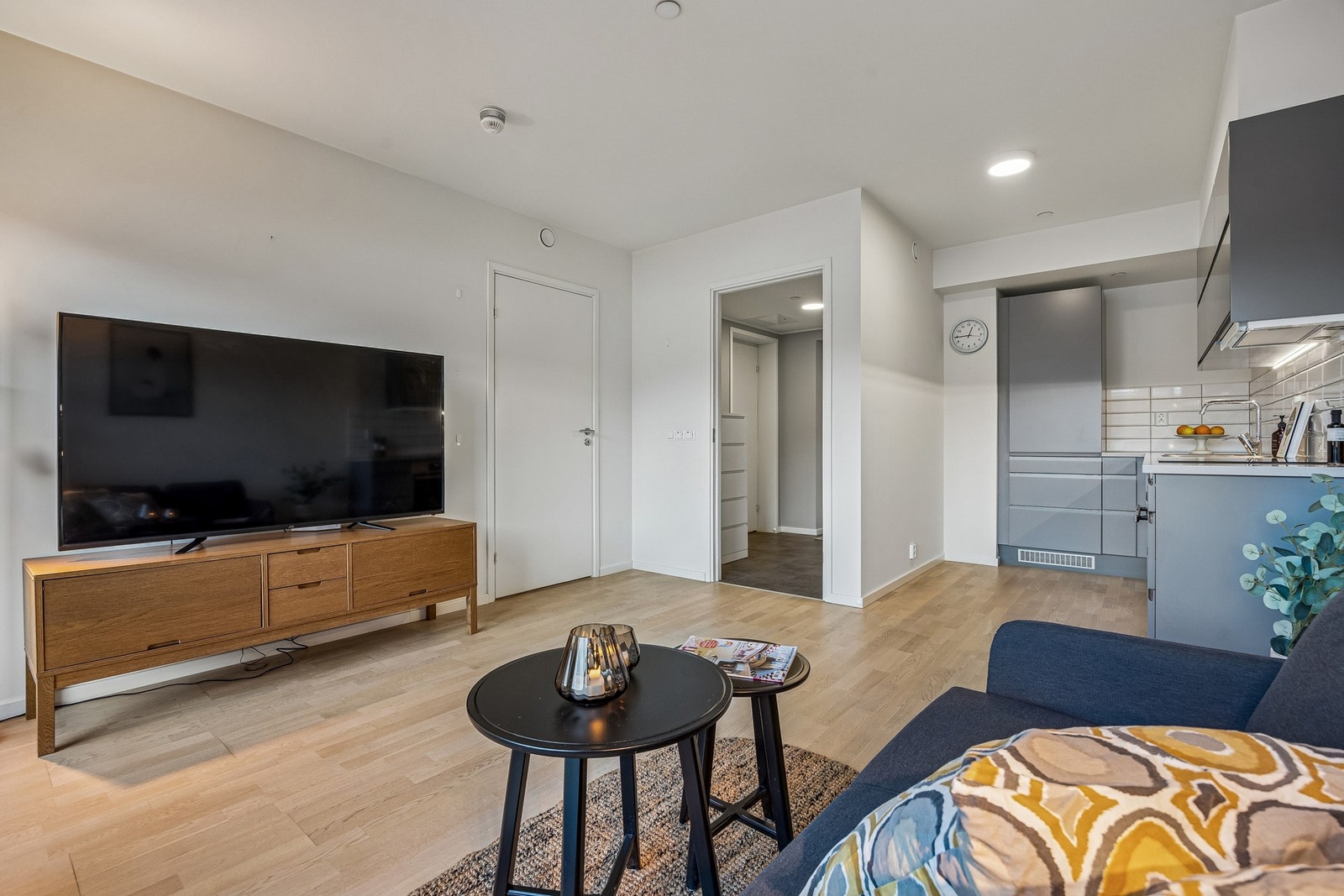 Stue og kjøkken er utformet i en åpen løsning som gir en romslig og sosial sone. Stuen har god plass til både sofagruppe og spisebord, og store vinduer samt utgang til balkong bidrar til en luftig romfølelse. Galleribilde