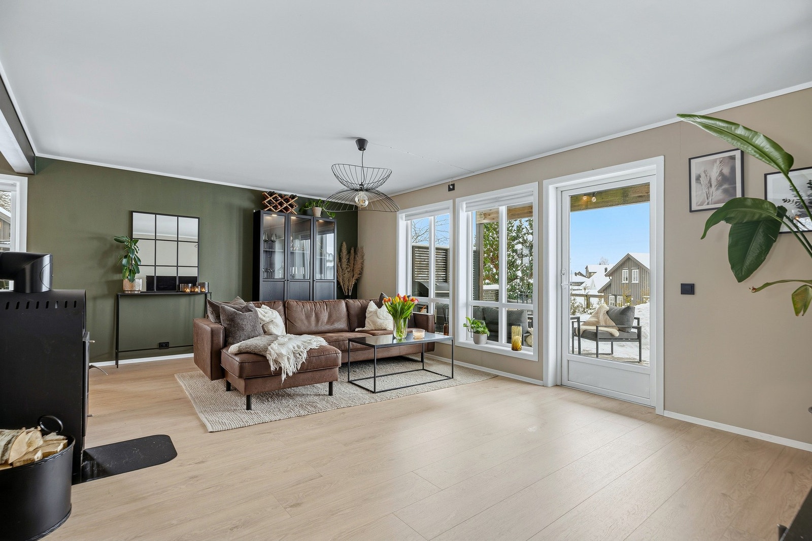 Stor og lys stue med pene overflater og peisovn Galleribilde