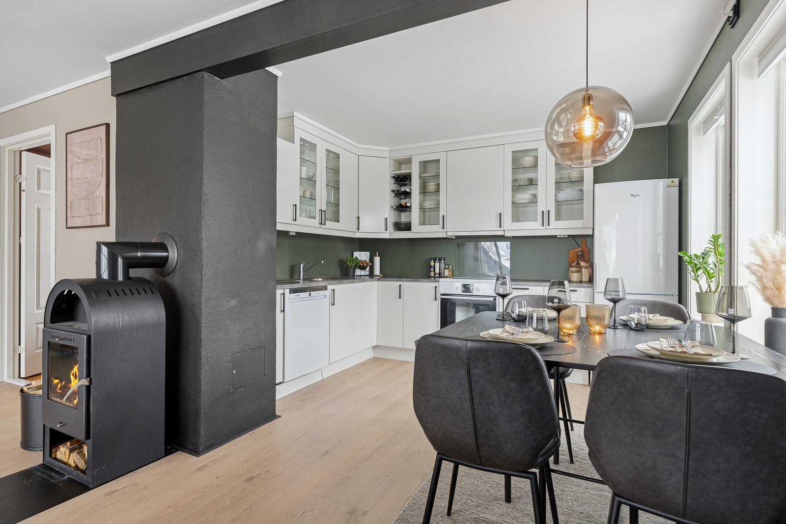 Kjøkkenets L-form gir god skapplass i både takhøye overskap og skap- og skuffeseksjoner under benk Galleribilde