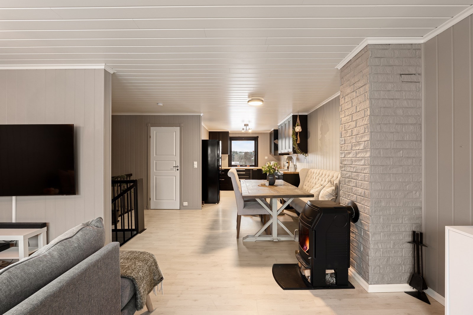 Vedovnen som står sentralt i stuen er til glede for både spisebordet og sofakroken. Galleribilde