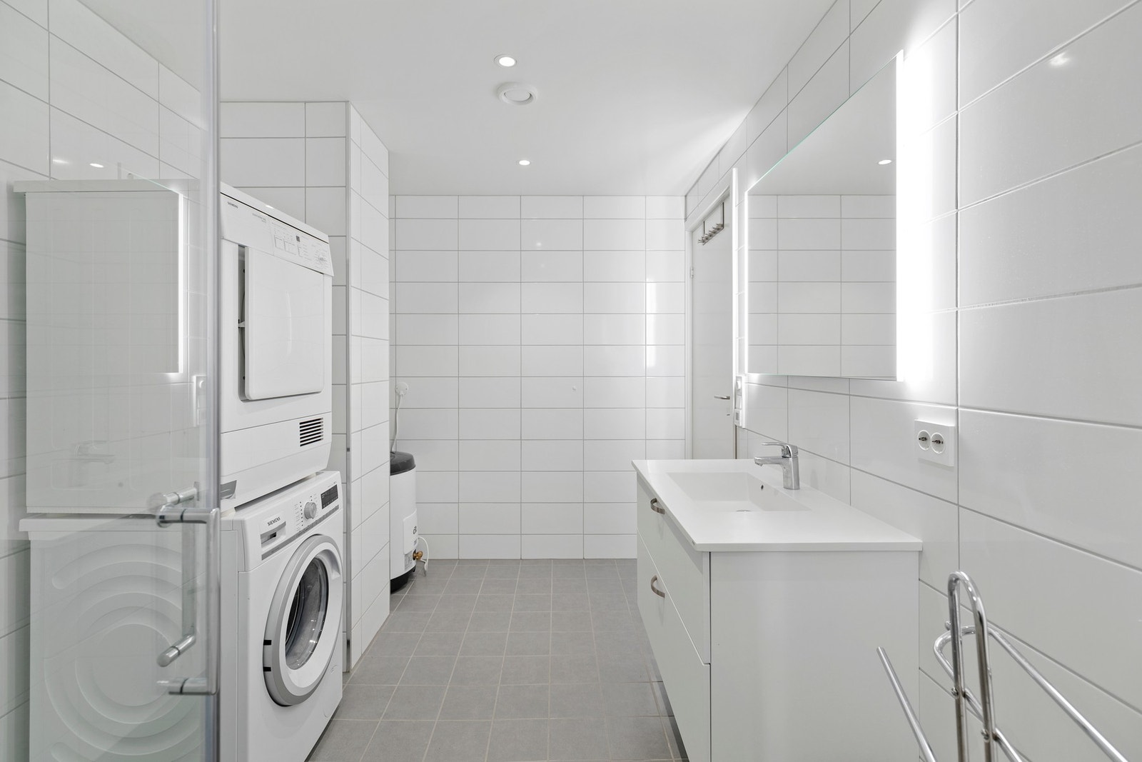 Av utstyrt er det montert gulvvarme, downlights, veggholdt toalett, baderomsinnredning, opplegg for vaskemaskin og åpen dusjnisje med glassdører Galleribilde