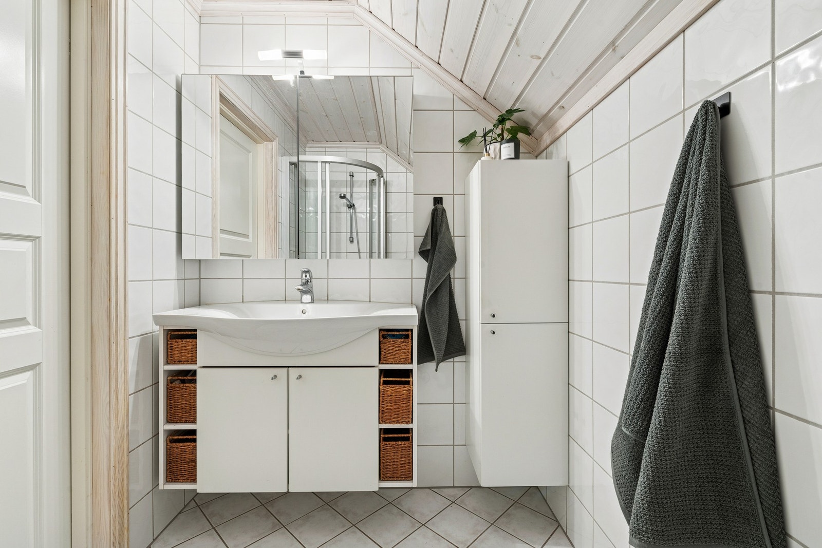 Badet i andre etasje er innredet med flislagte overflater og har dusjløsning, servant og toalett. Galleribilde