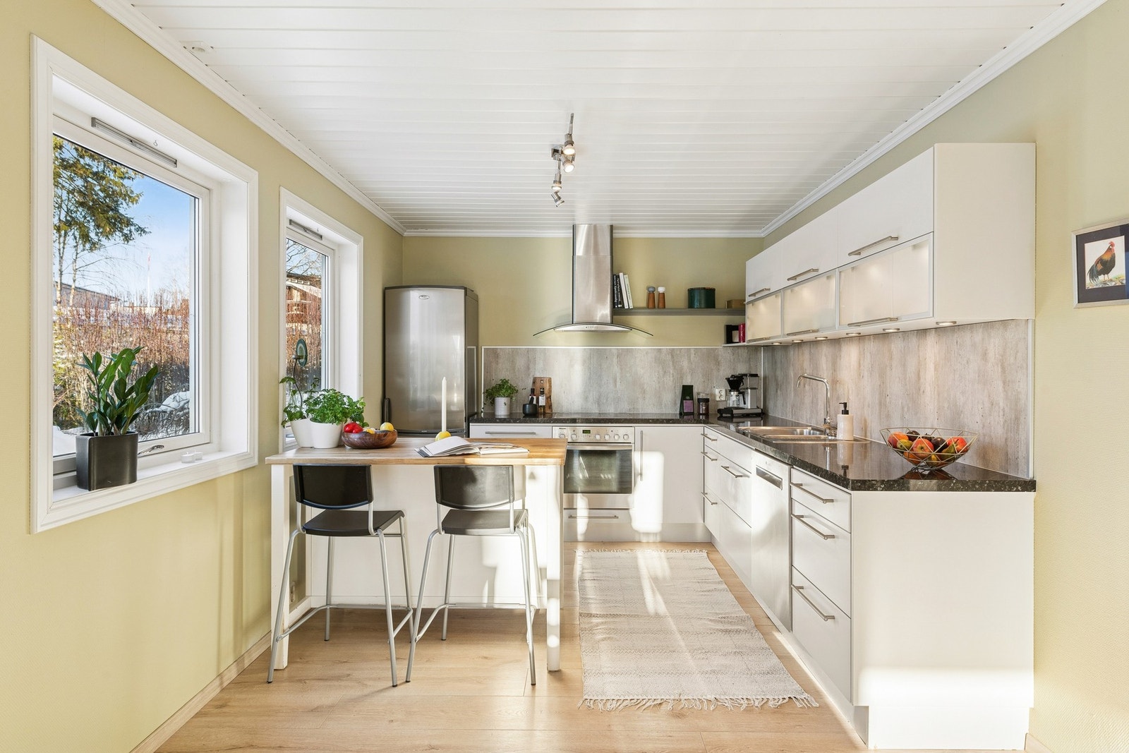 Kjøkkenet ligger i åpen løsning mot spisestue og har en praktisk utforming med gode arbeidsflater og rikelig skap og benkeplass. Galleribilde