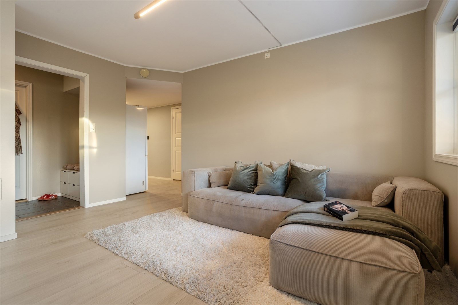 Romslig stue med naturlige fargevalg og behagelig lyssetting. Galleribilde