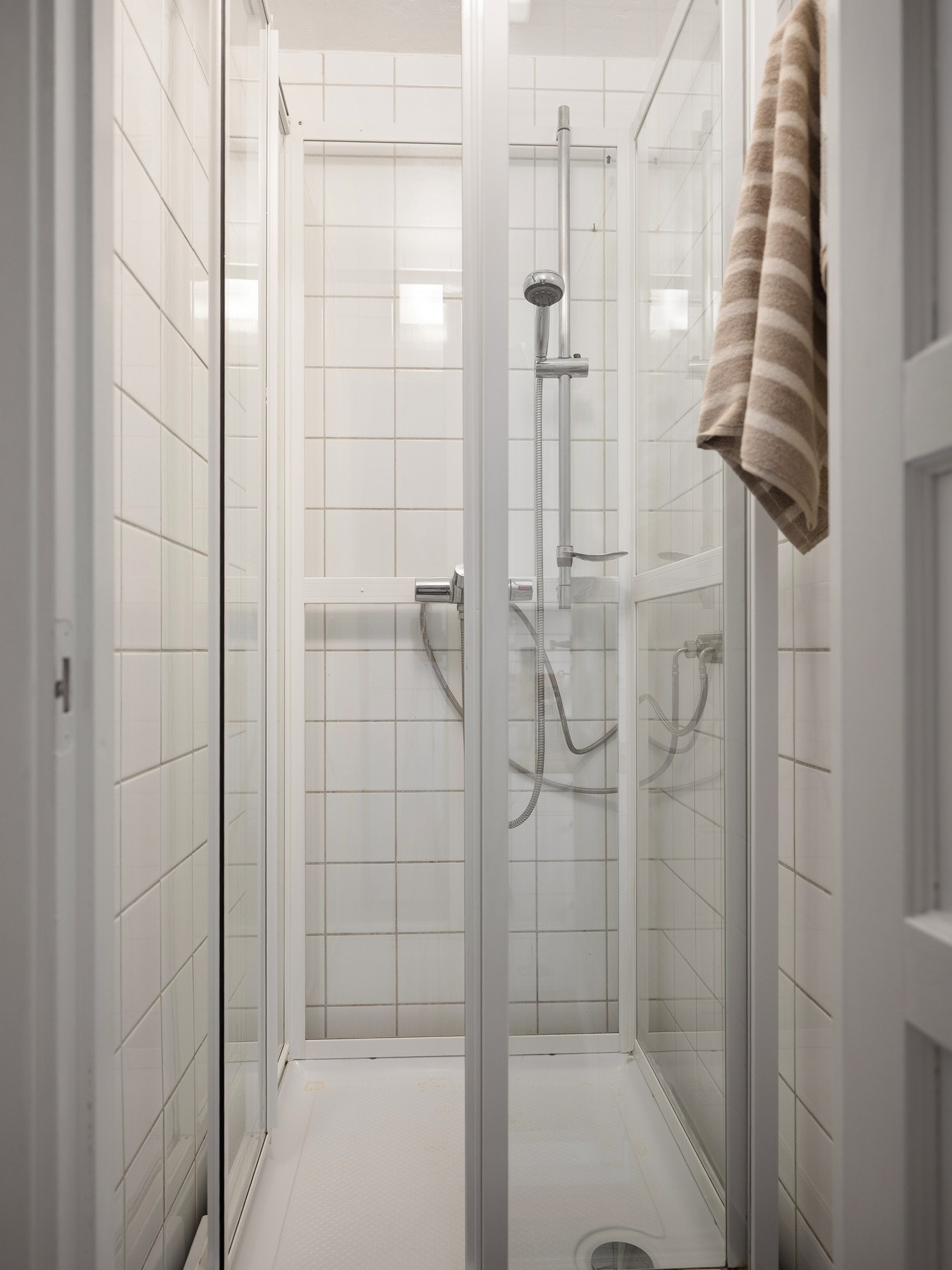 Separat dusjrom med flislagte overflater og dusjkabinett. Galleribilde