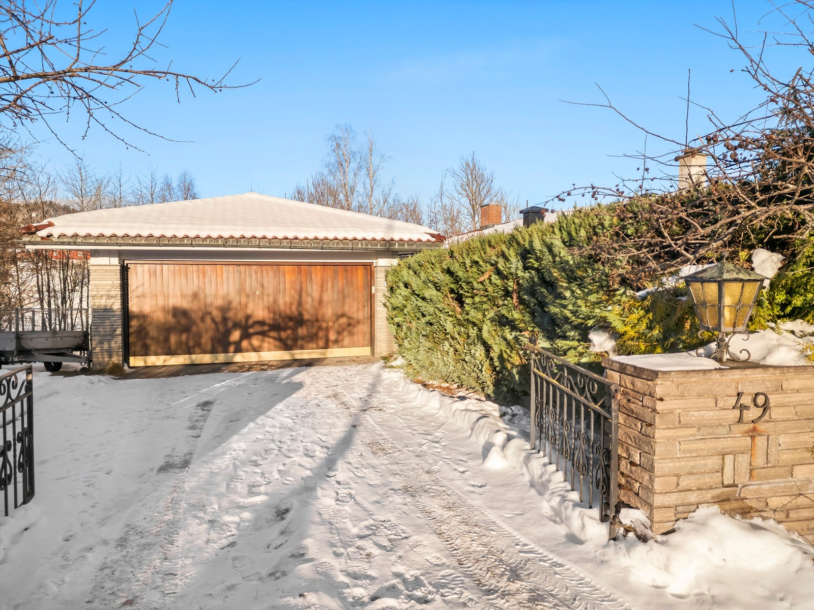 Pent opparbeidet eiendom med portstolper og smijernsport ved innkjørselen. Asfaltert gårdsplass og stor (43 kvm) garasje med god plass til parkering og lagringsplass. Galleribilde