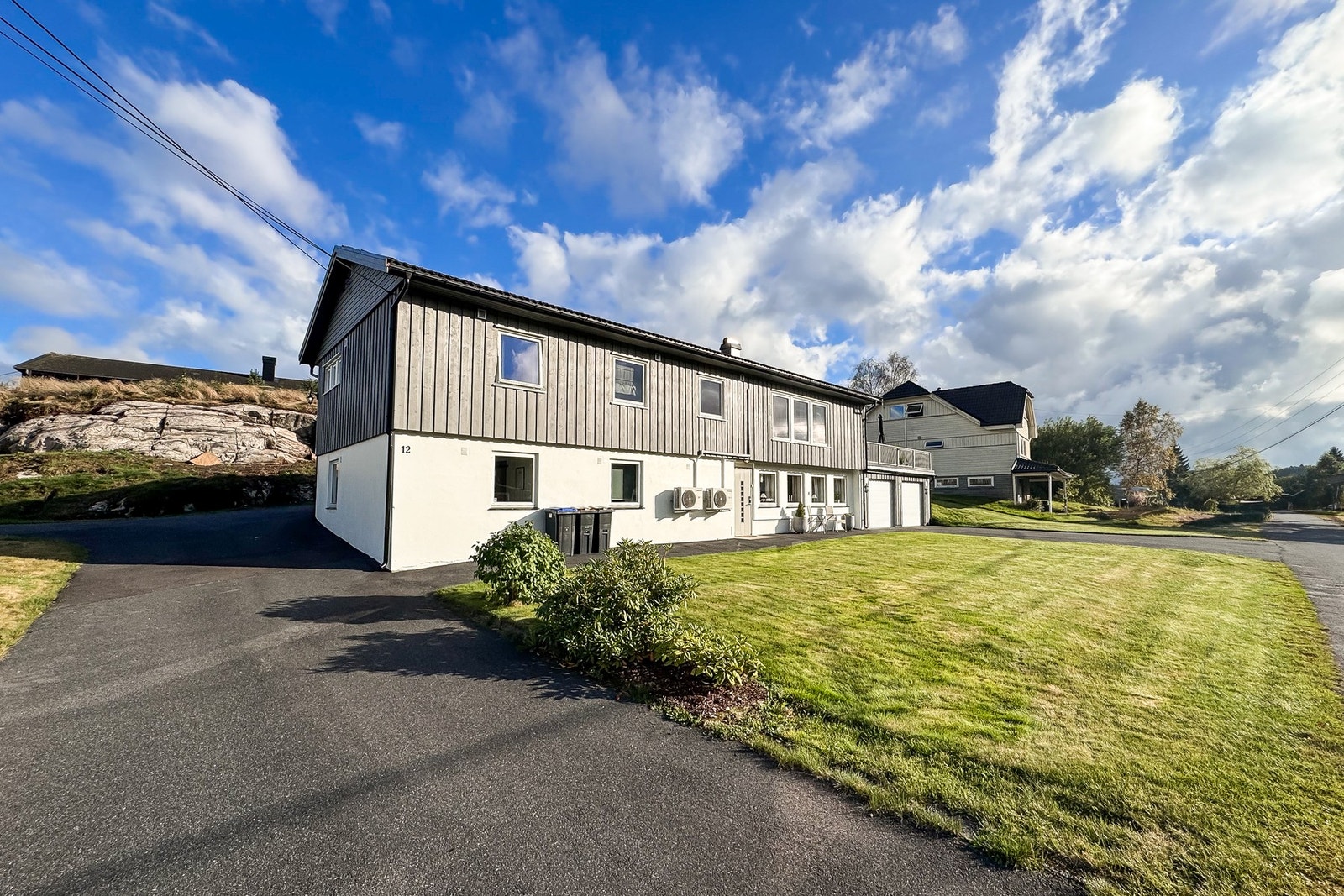 Pent opparbeidet uteområde med plen og asfaltert tun. Galleribilde