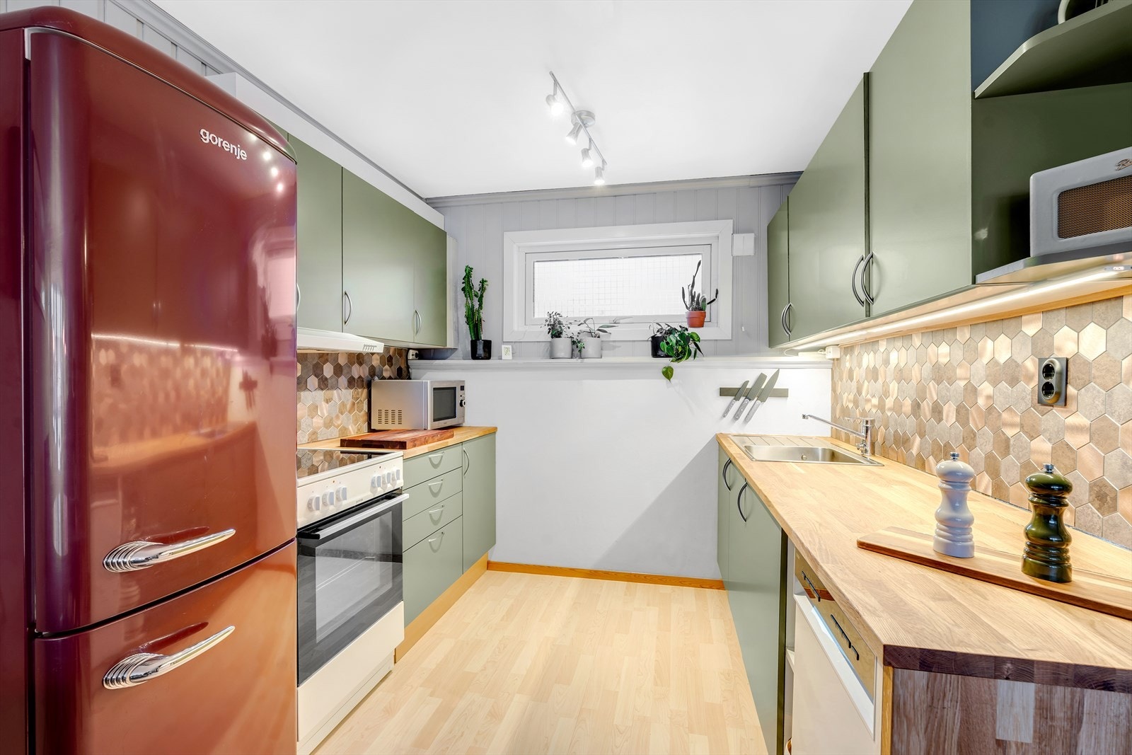 Flott kjøkken med slette fronter og benkeplate av heltre, samt rikelig med skap-og benkeplass. Galleribilde