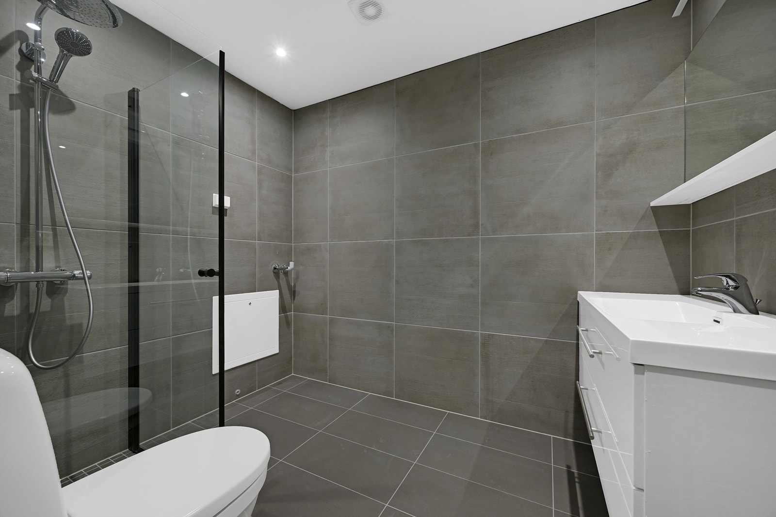 Delikat flislagt bad med elektriske varmekabler og spotter i taket. Galleribilde