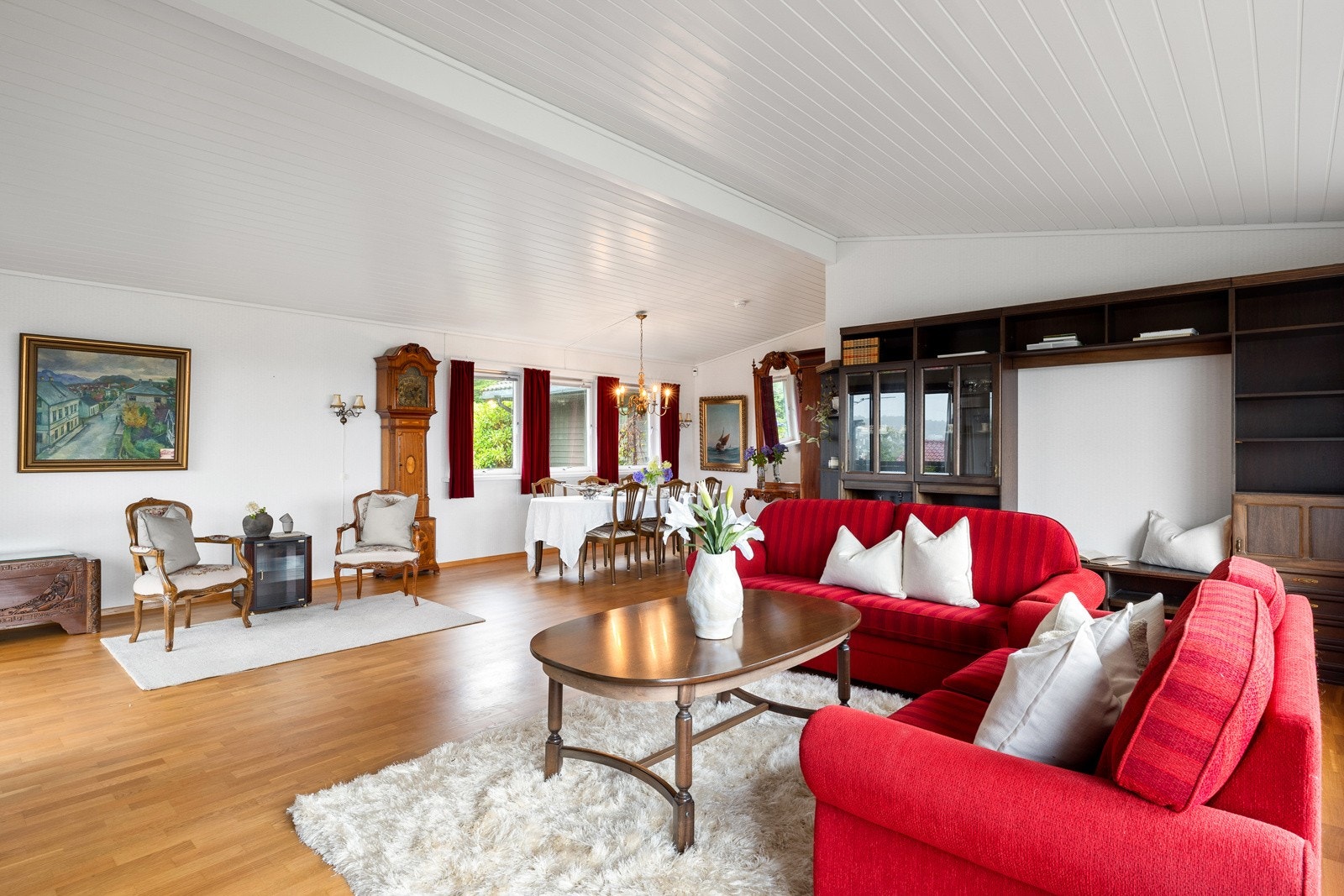 Parkettgulvet kombineres med hvite vegger, og med både peis og varmepumpe får man det lunt og godt i stuen. Galleribilde