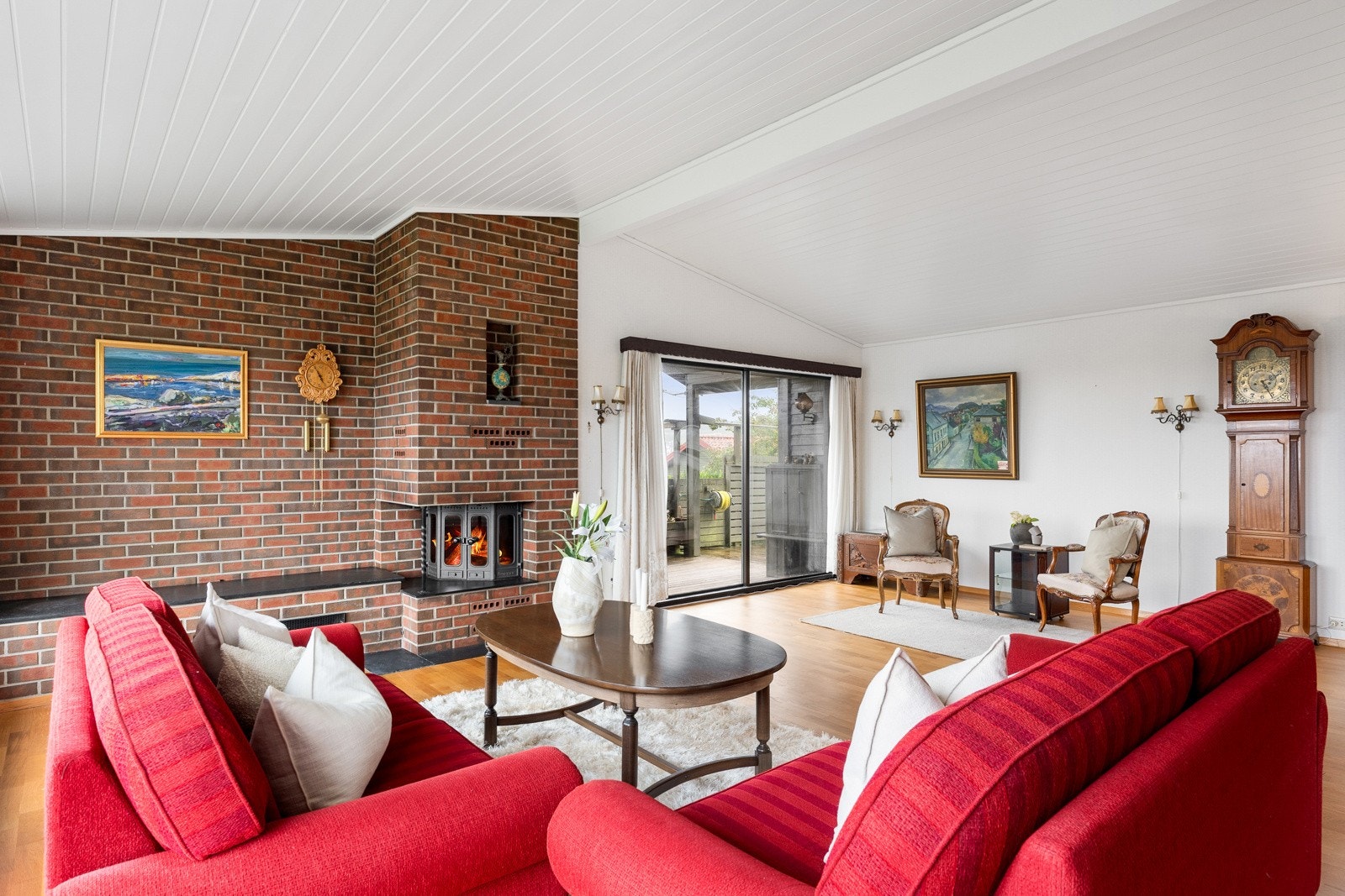 Peisen er kledd med teglstein, og stuen innredes enkelt med flere sittegrupper. Galleribilde