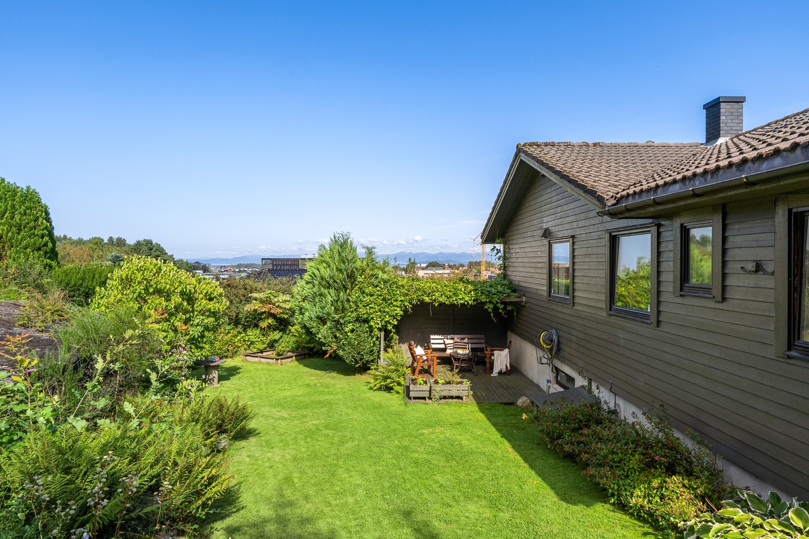 Terrassen er usjenert, og har en levegg med hengeplanter som overbygg. Galleribilde