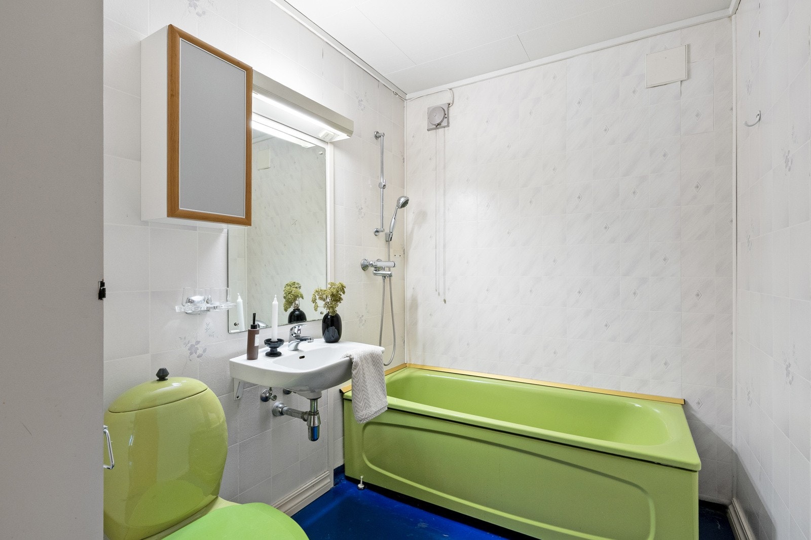 Badet nede er innredet med betonggulv og våtromstapet på veggene. På badet er det, servant. toalett og matchende badekar med dusjløsning. Galleribilde