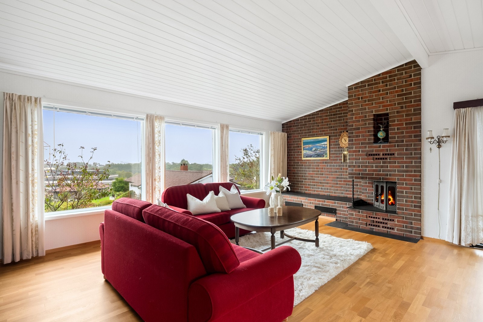 Stuen er åpen og meget romslig, der store vindusflater i tre retninger sørger for gode lys- og utsiktsforhold Galleribilde