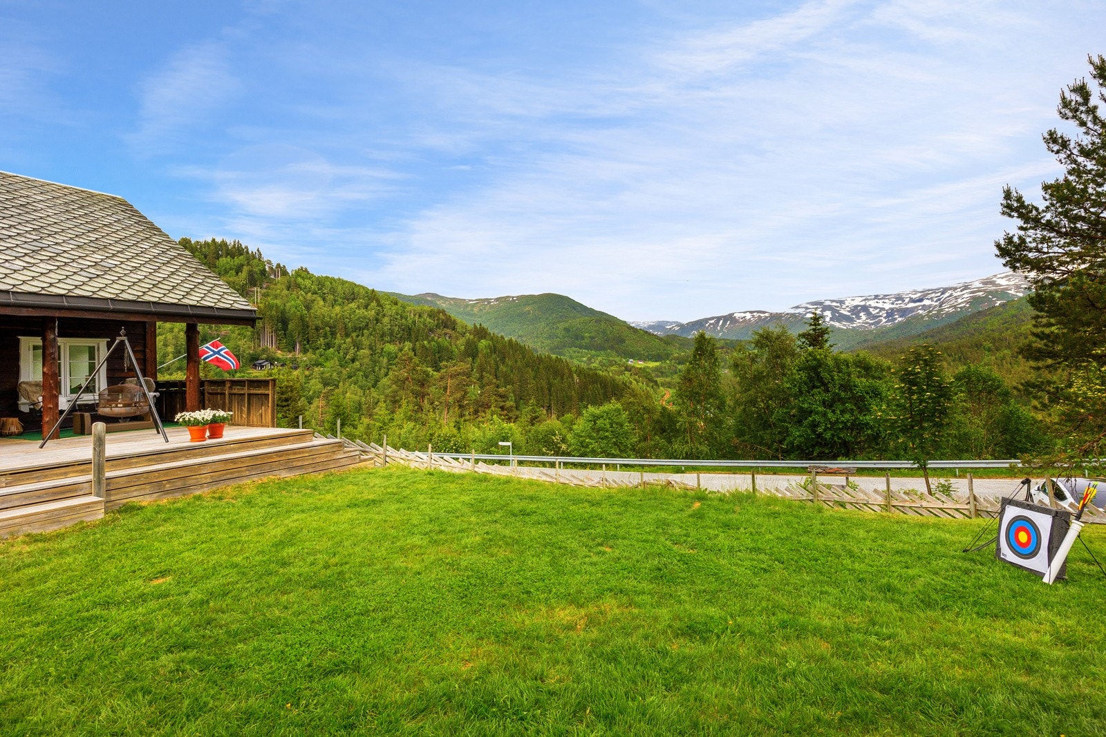 Den store flate hagen med den deilige plenen hvor barna løper i vannspreder og bader i basseng om sommeren, byggger snømenn og tar sine første steg med ski på beina om vinteren. Galleribilde
