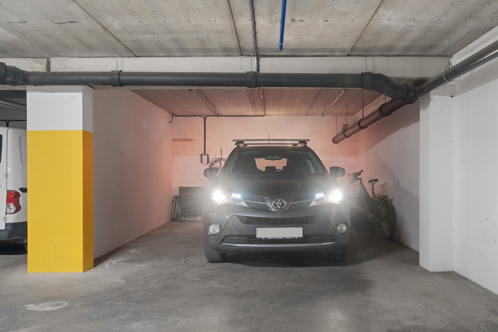 Leiligheten har en medfølgende parkeringsplass i kjeller. Plassen har bredde på 4,4 m og lengde på 5,6m. Dette gir plass til både bil, motorsykkel og flere sykler. Galleribilde