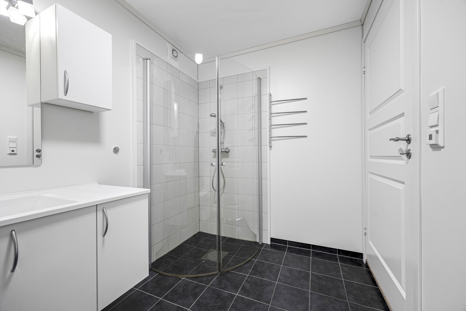 Flislagt gulv og vegger med våtromsplater gir et stilrent bad. Mekanisk avtrekk sikrer god ventilasjon. Galleribilde