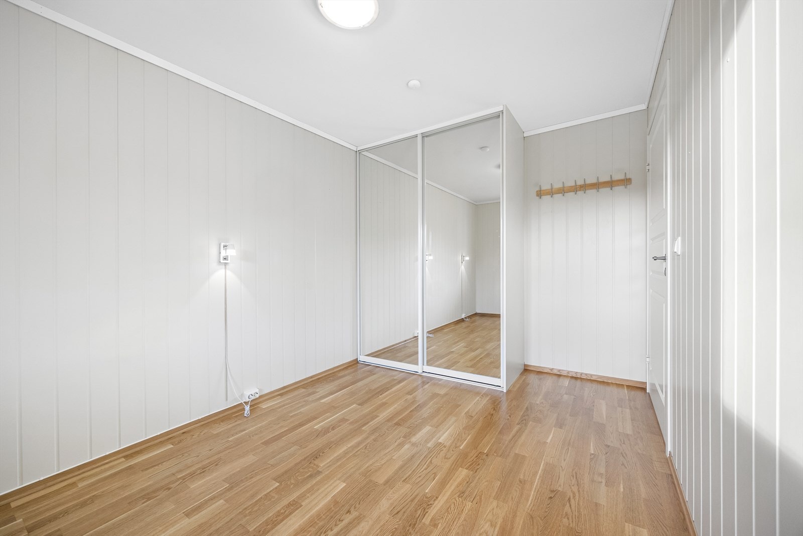 Skyvedørsgarderobe gir effektiv oppbevaring og speil skaper dybde. Galleribilde