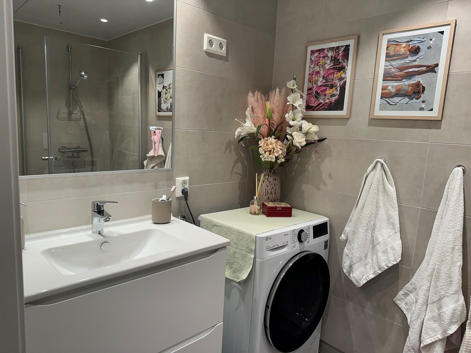 Moderne, helfliset bad med servant, toalett, dusj og kombinert vaskemaskin/tørketrommel. Galleribilde