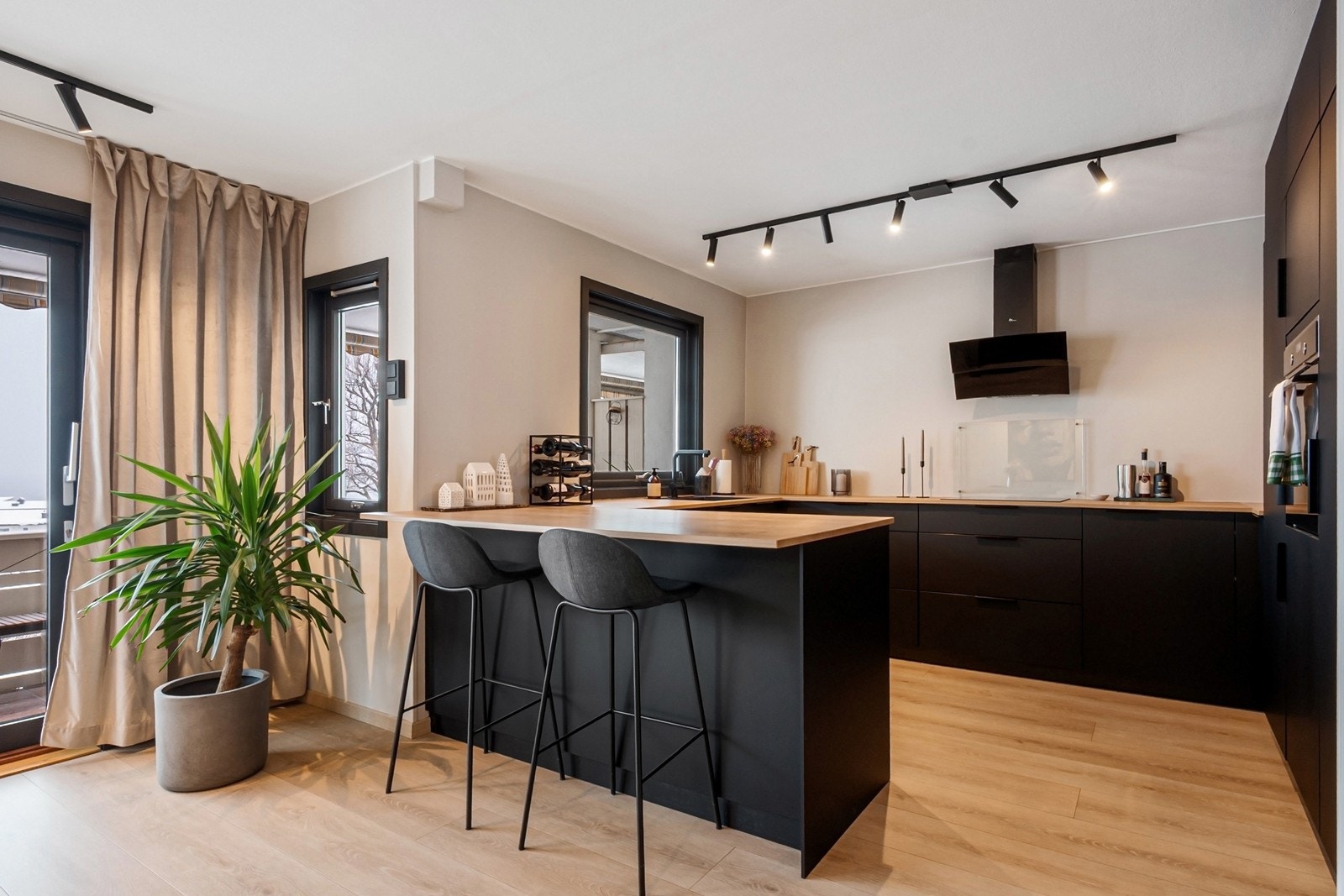 Halvøya gir ekstra arbeidsflate og skaper en naturlig overgang mot stuen, samtidig som den har plass til barstoler for uformelle måltider og hyggelige samlingspunkter. Galleribilde