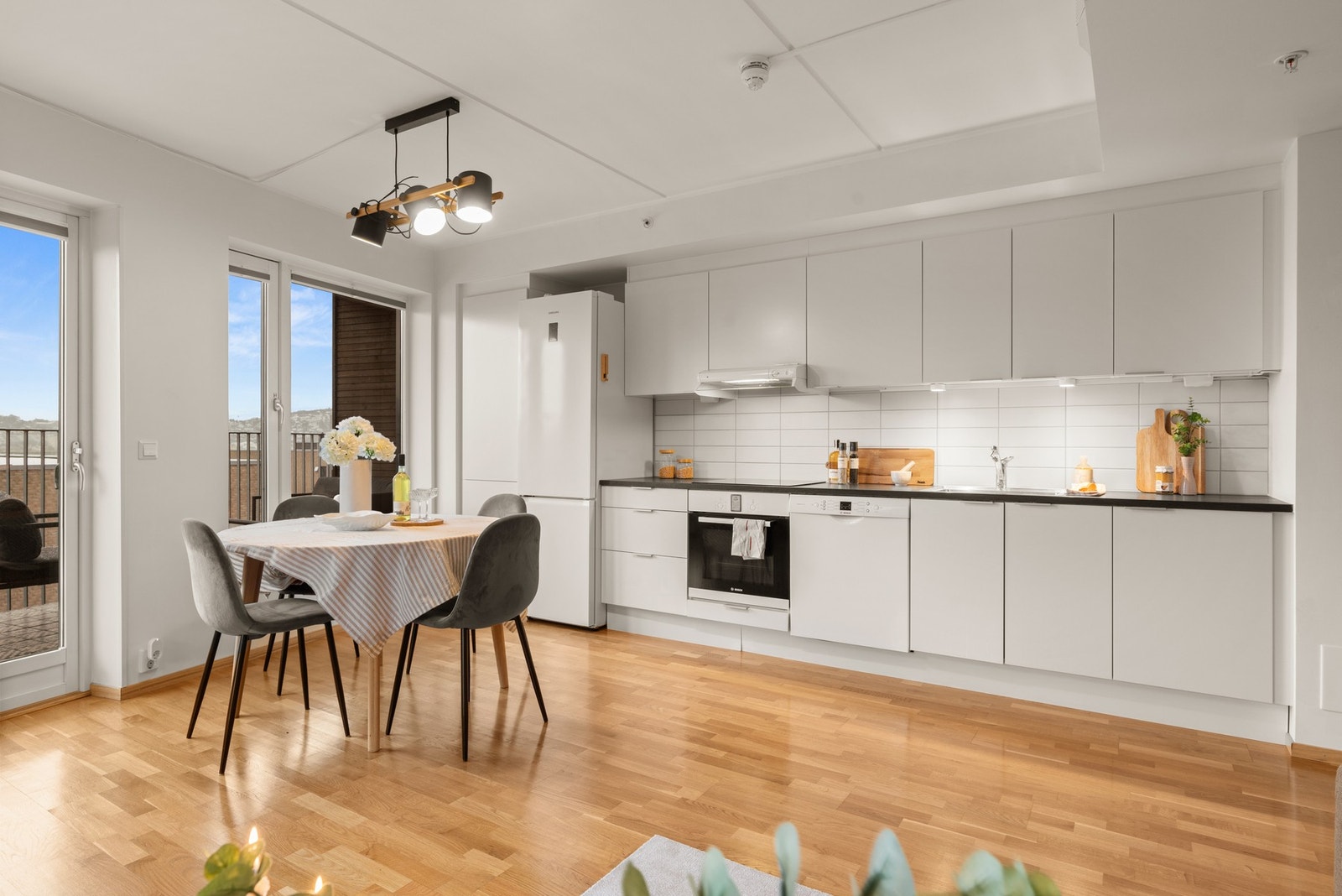 Lettstelt kjøkken med hvite, slette skapfronter og veggfliser.
Alle hvitevarer kan medfølge. Galleribilde